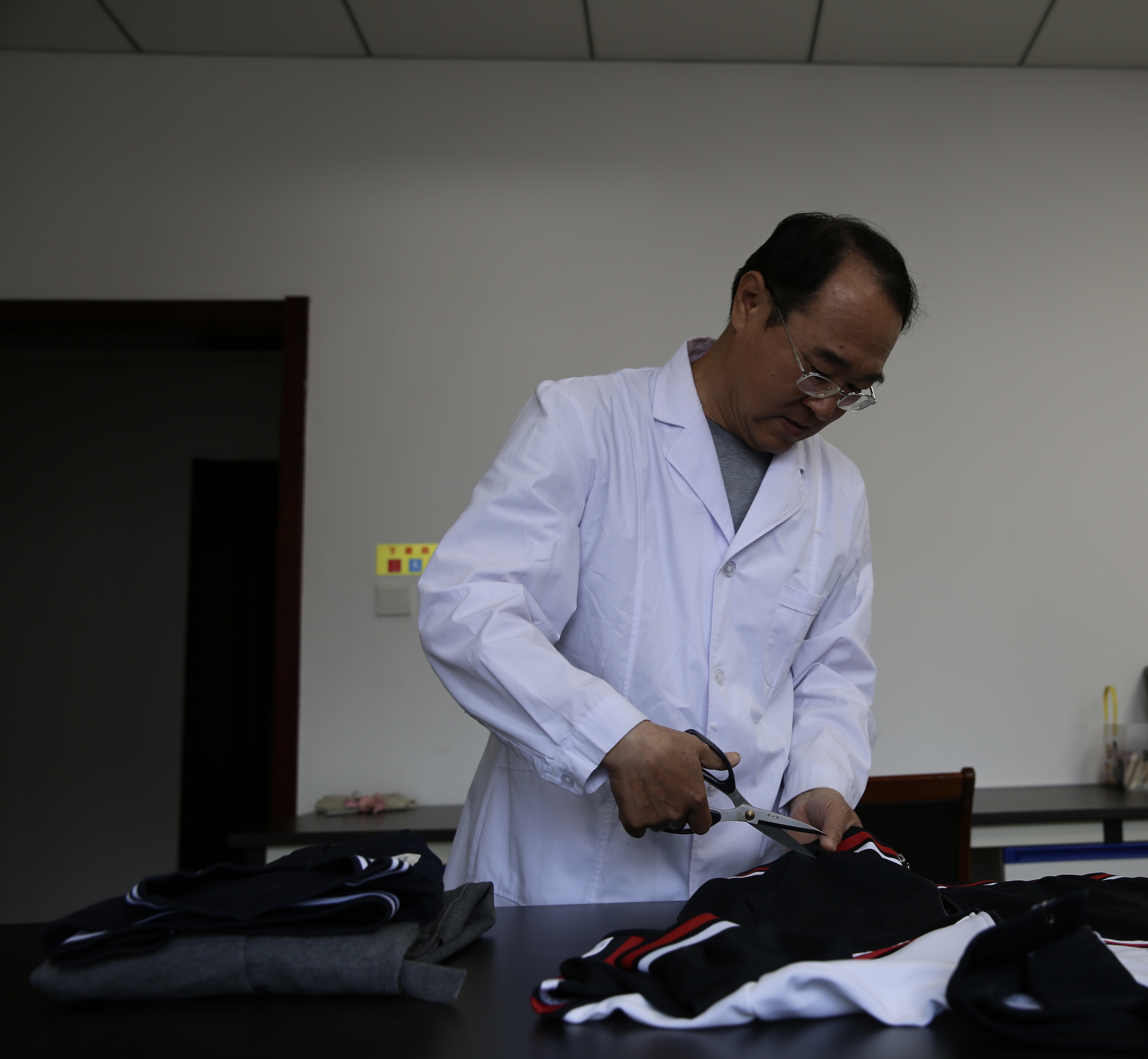 3.图为唐山市纤检所检验人员对学生服进行试样制备.JPG